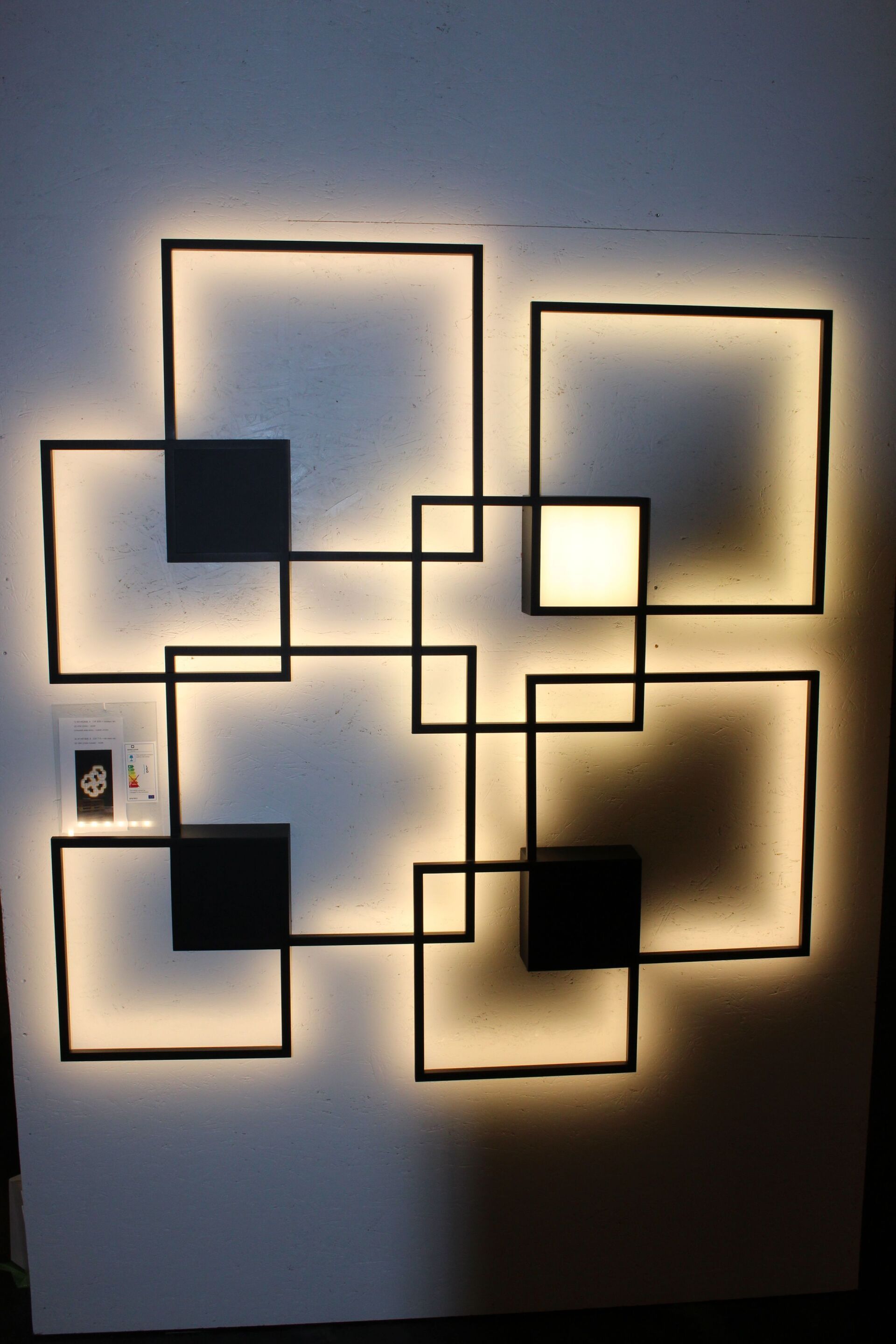 An einer Wand befindet sich ein Licht, das wie ein Labyrinth aussieht.