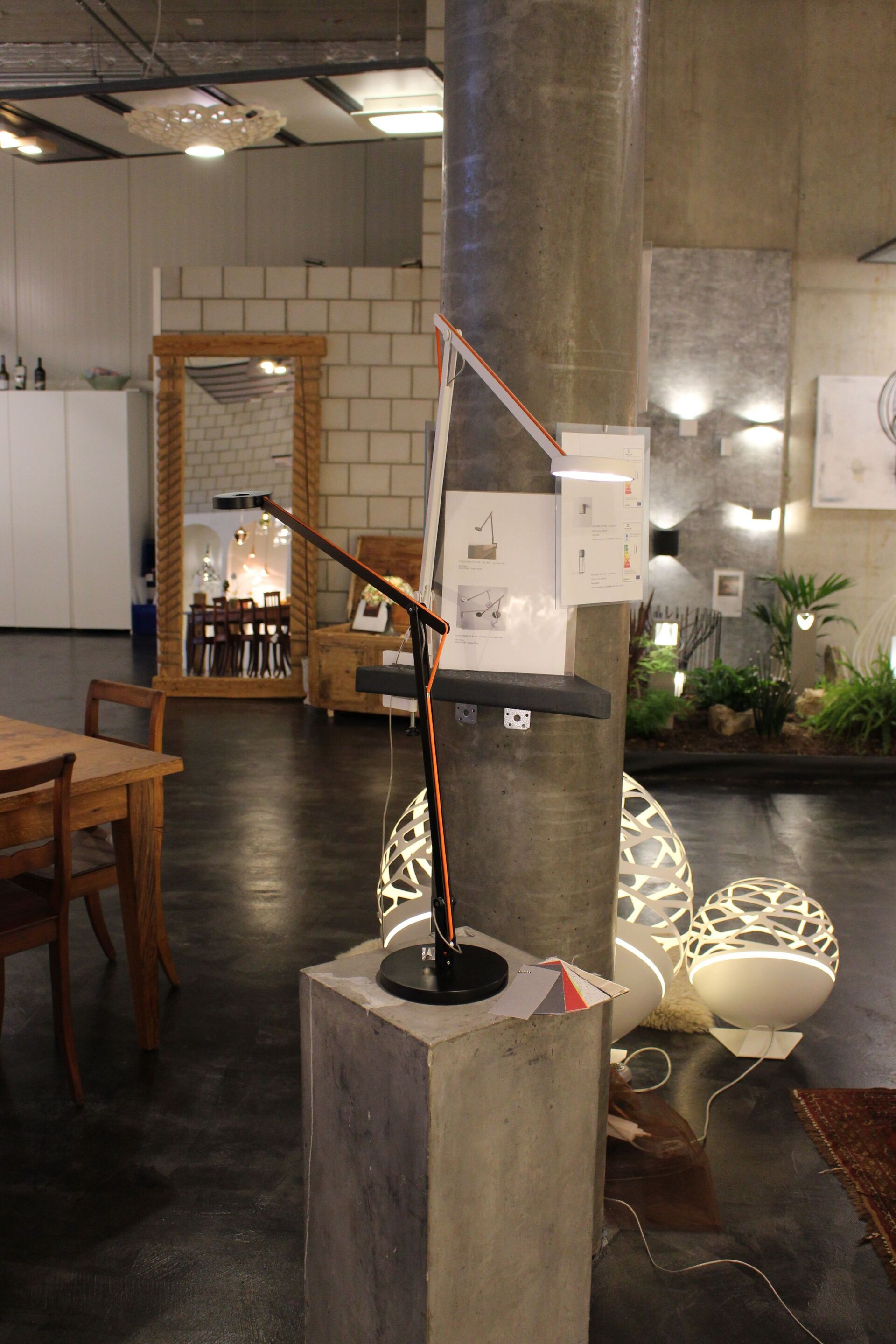 In einem Raum steht eine Lampe auf einem Betonblock.