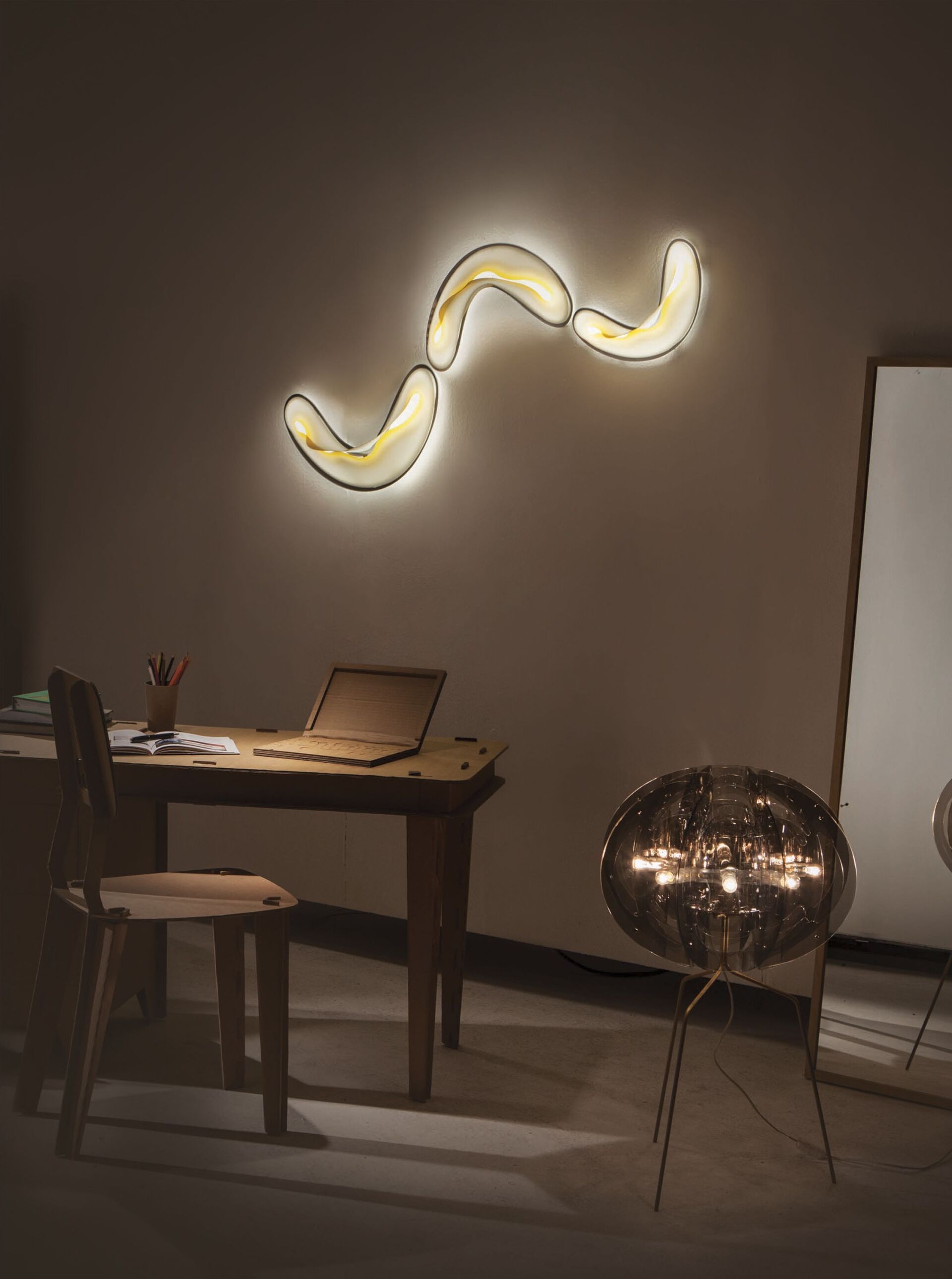 Ein Zimmer mit einem Schreibtisch und Stühlen und einem Laptop darauf