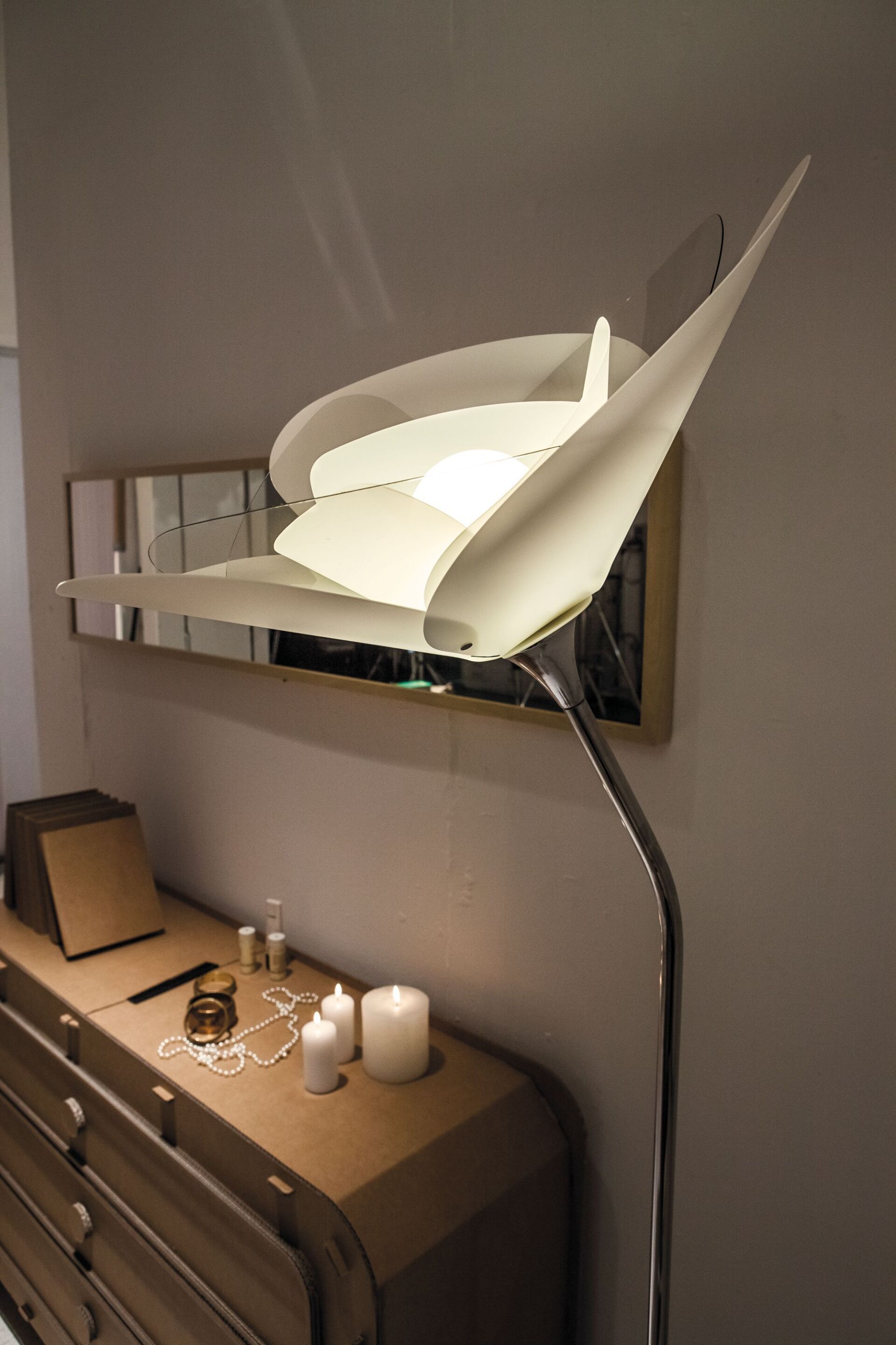 Eine Lampe auf einer Kommode neben Kerzen