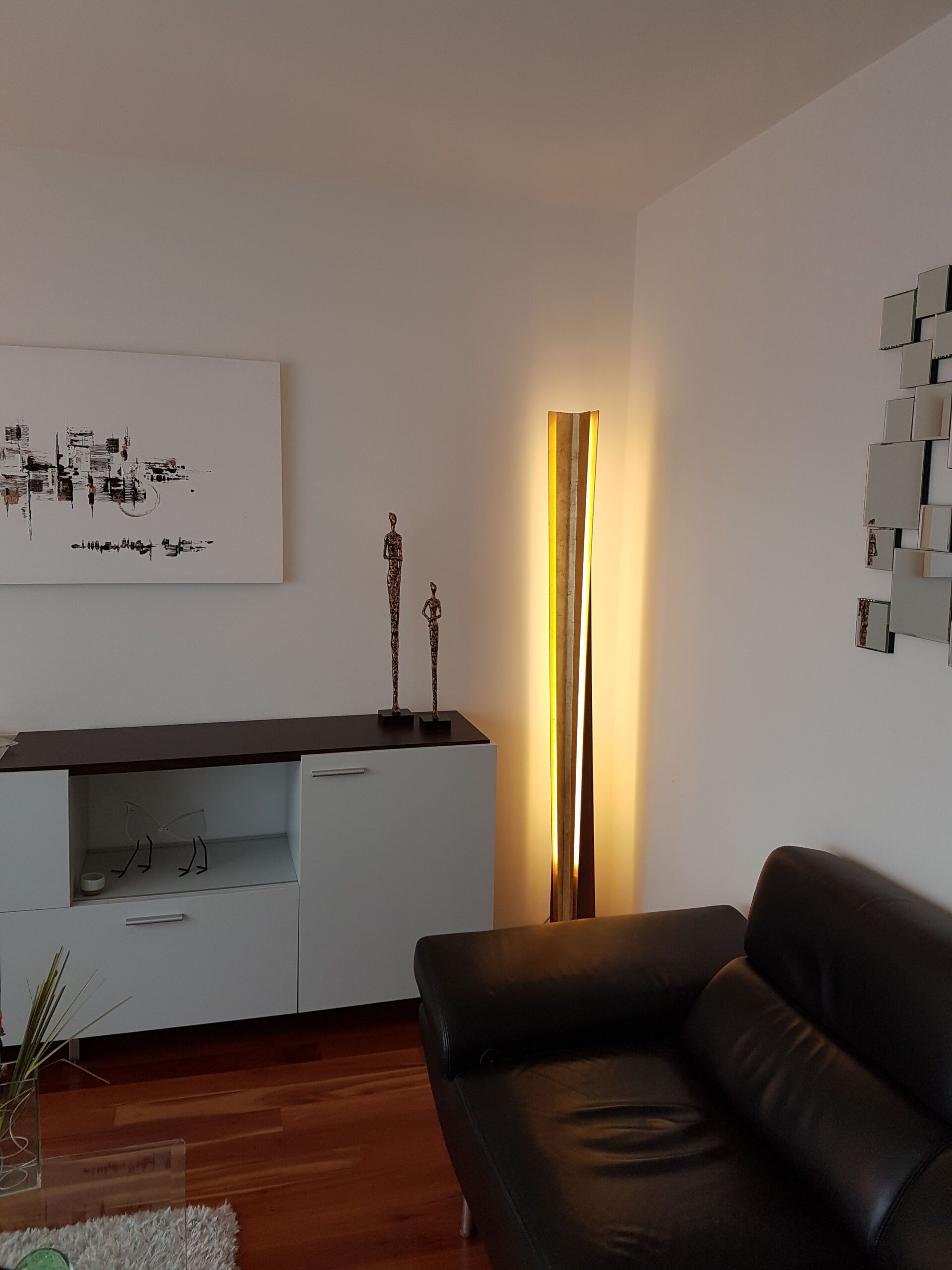 Ein Wohnzimmer mit einer Couch und einem Gemälde an der Wand