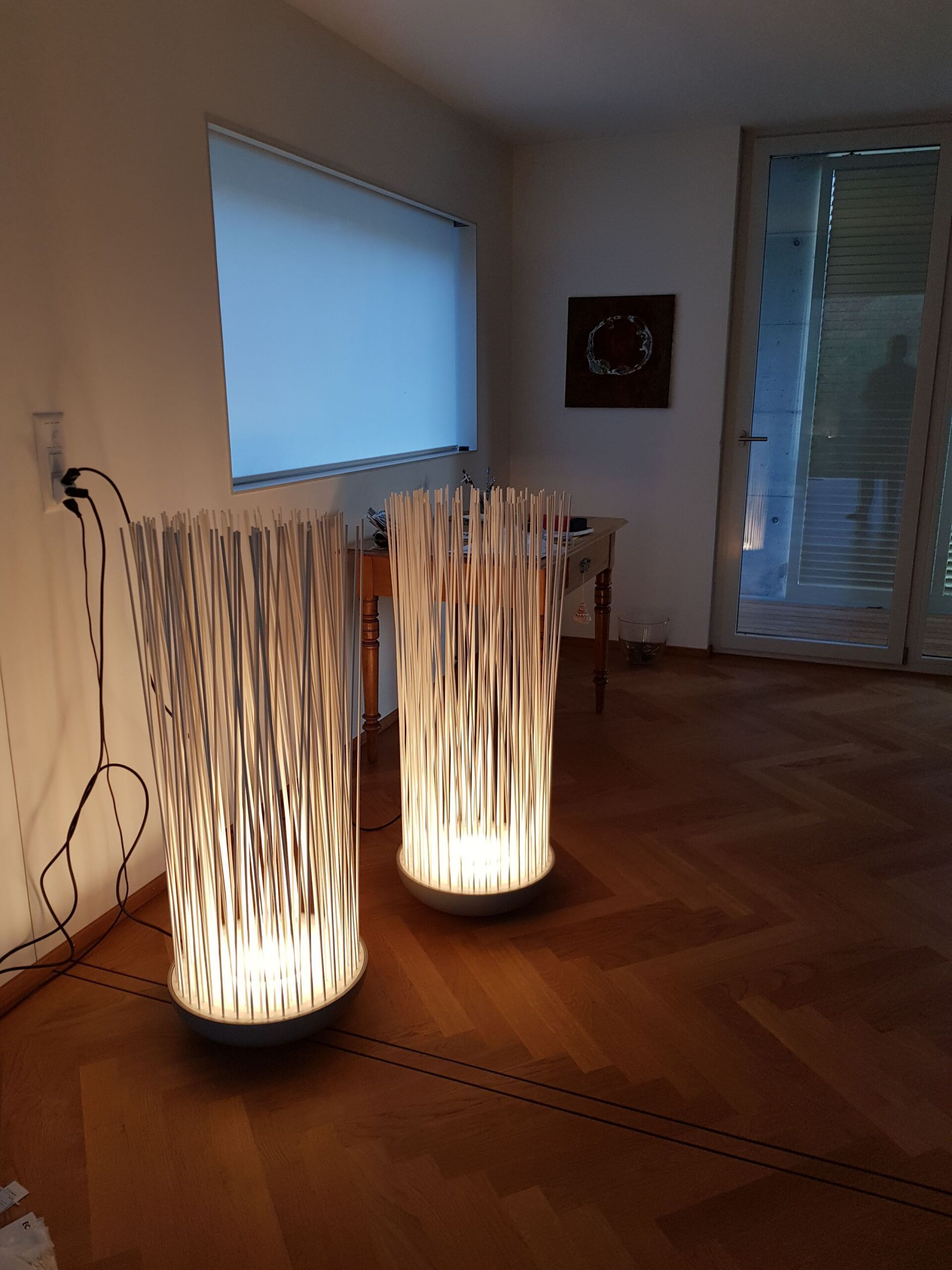 Zwei Lampen stehen auf einem Holzboden in einem Wohnzimmer.