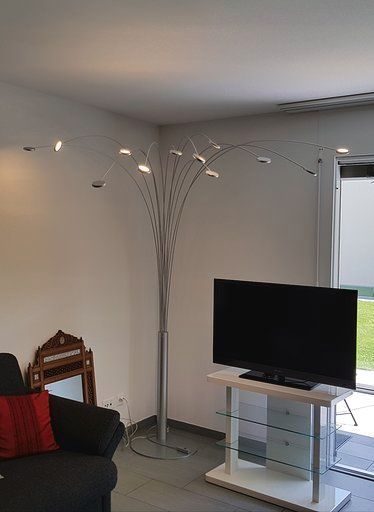 Ein Wohnzimmer mit Couch, Fernseher und Lampe.