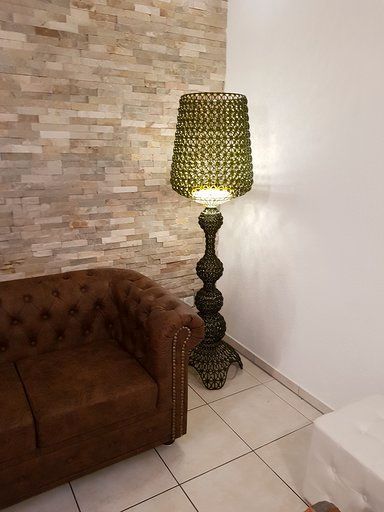 Ein Wohnzimmer mit einer braunen Couch und einer grünen Lampe.
