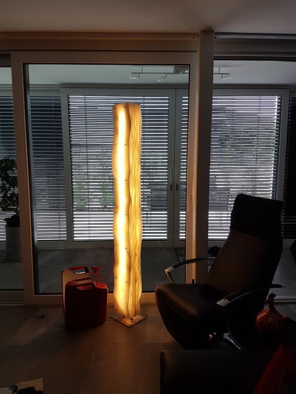 Ein Wohnzimmer mit einem Stuhl und einer Lampe