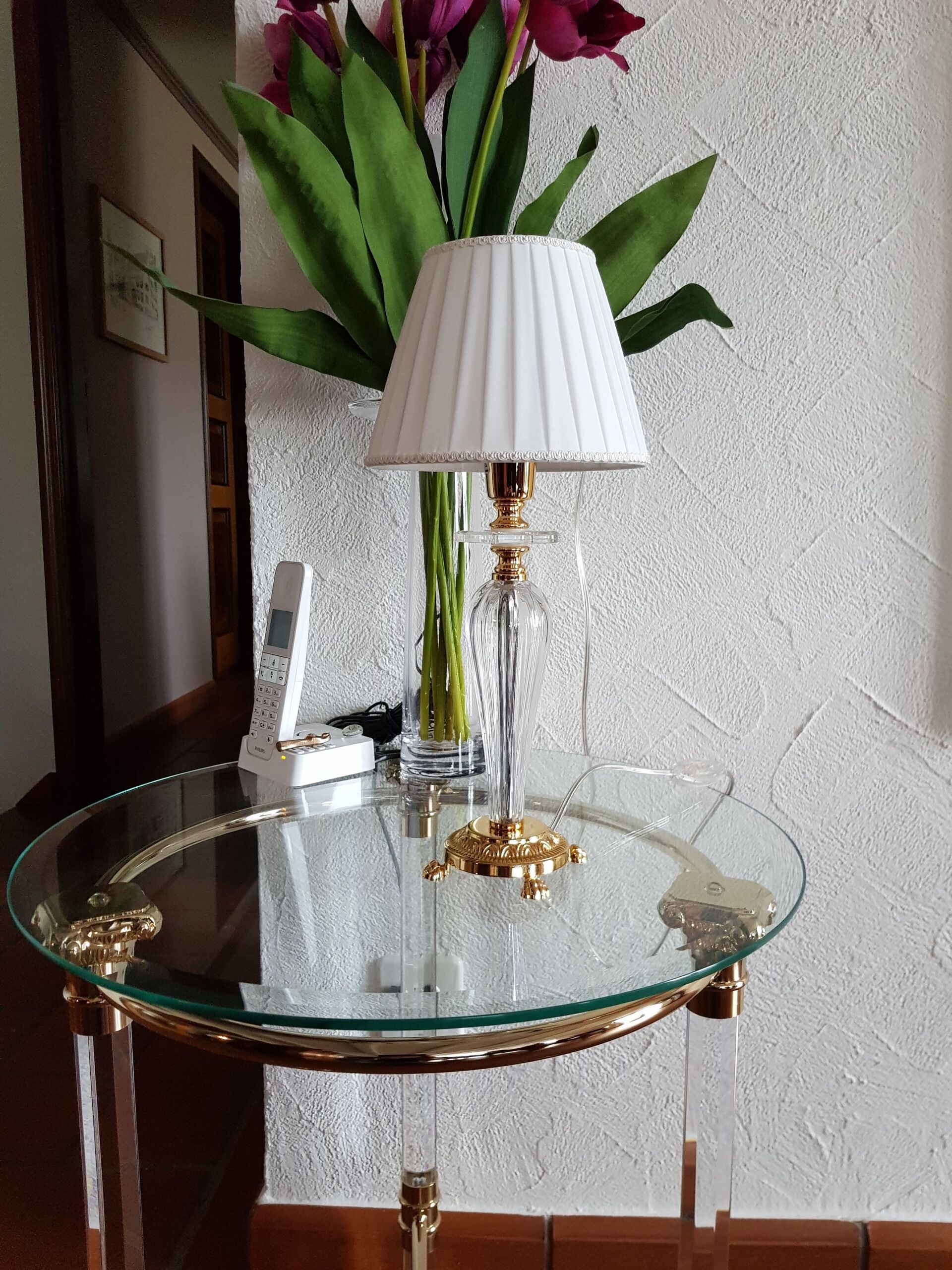 Ein Tisch mit einer Lampe und einer Vase mit Blumen darauf