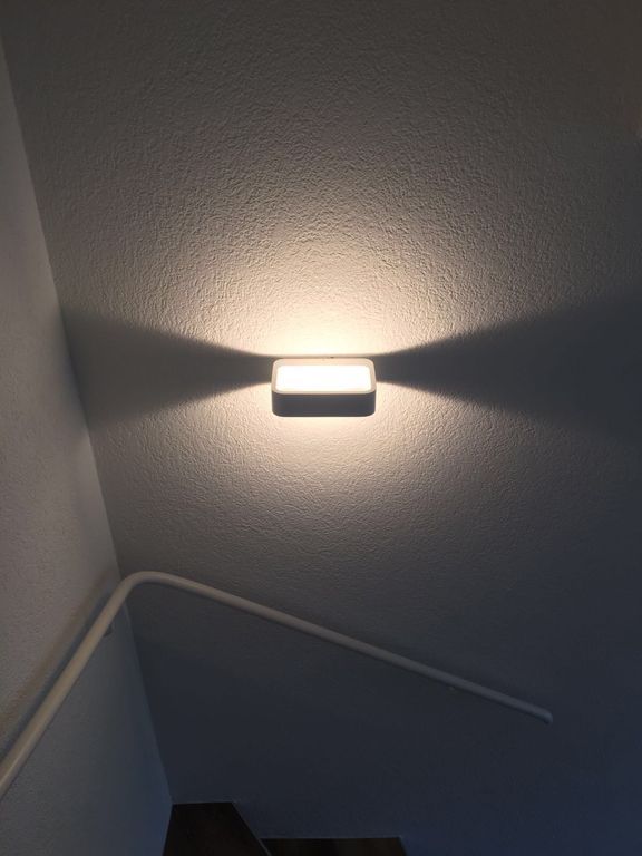 Ein Licht scheint auf eine Wand neben einer Treppe.