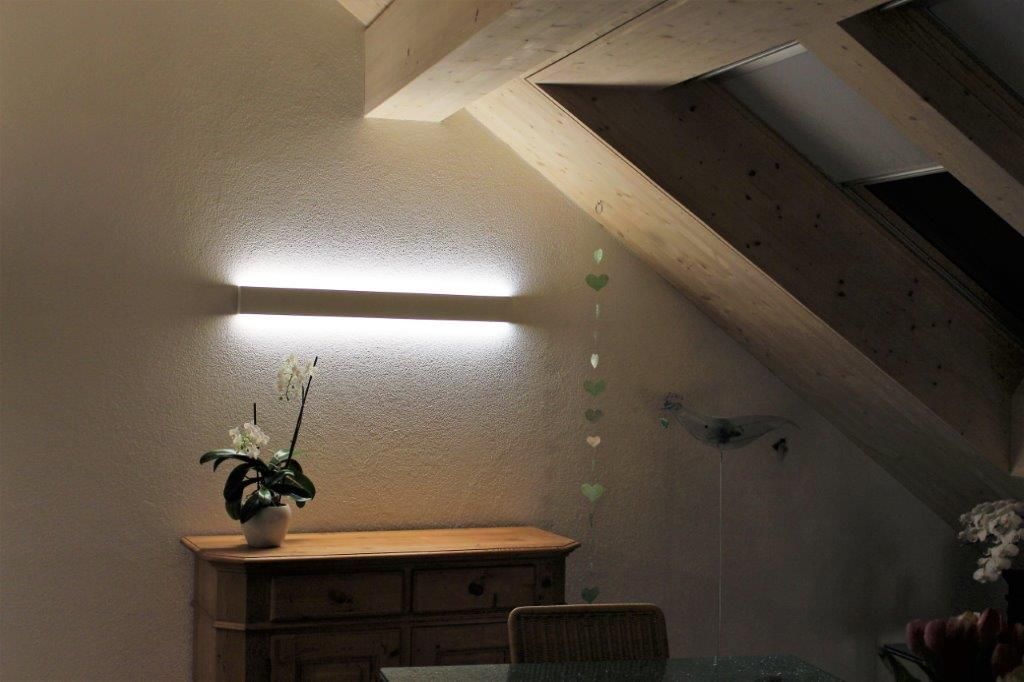 Eine Vase mit Blumen steht auf einer Kommode in einem Zimmer