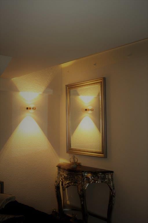 Ein Raum mit einem Tisch und einem Spiegel an der Wand.