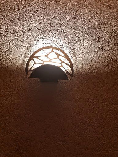 Ein Licht scheint auf eine braune Wand.