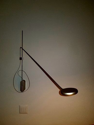 Eine Lampe hängt an einer Wand neben einem Lichtschalter.