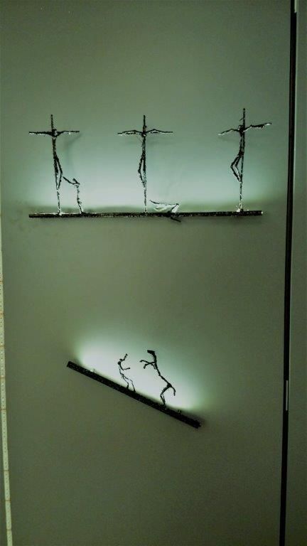 Eine weiße Wand mit ein paar Skulpturen darauf