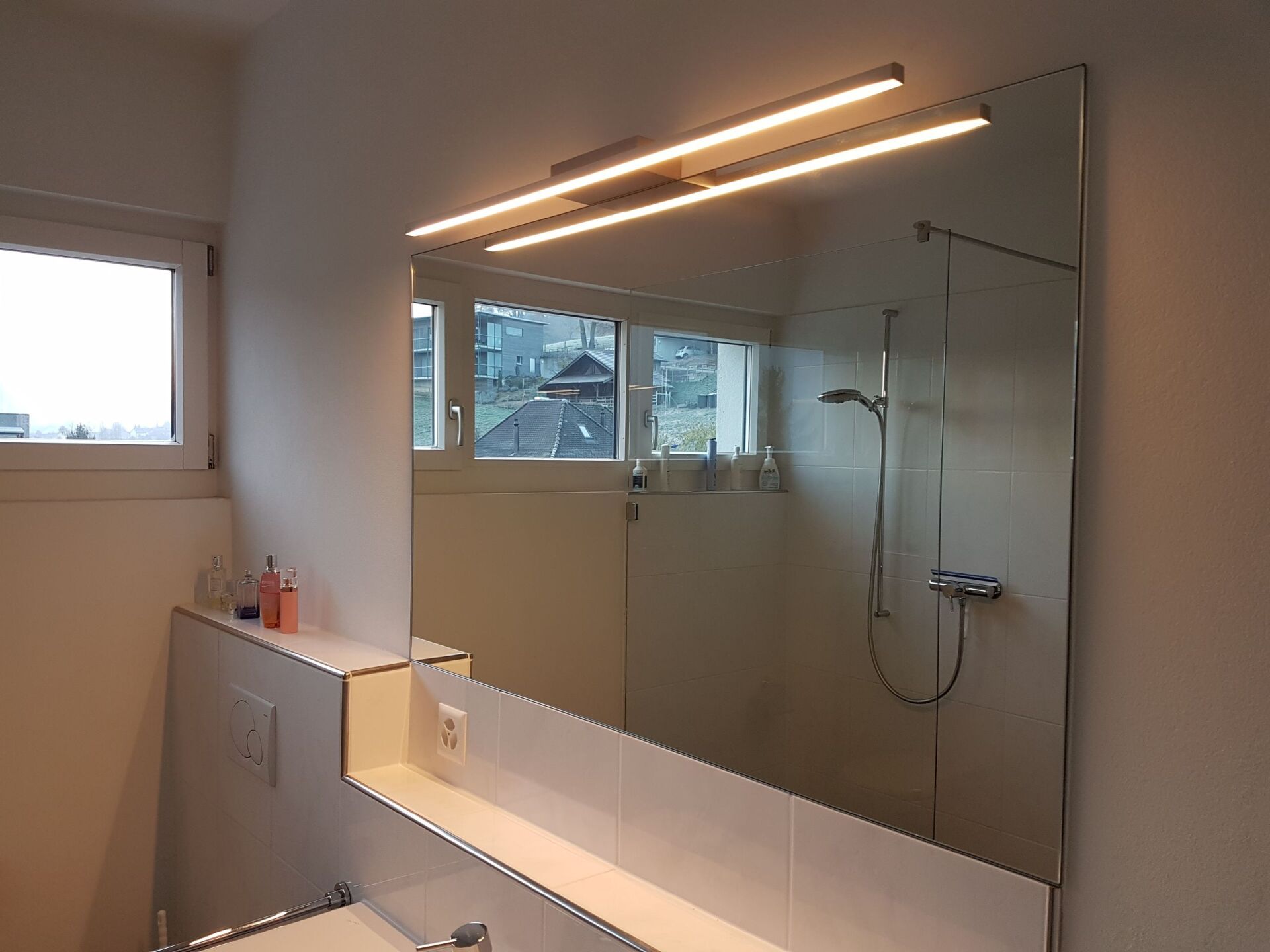 Ein Badezimmer mit großem Spiegel und Dusche