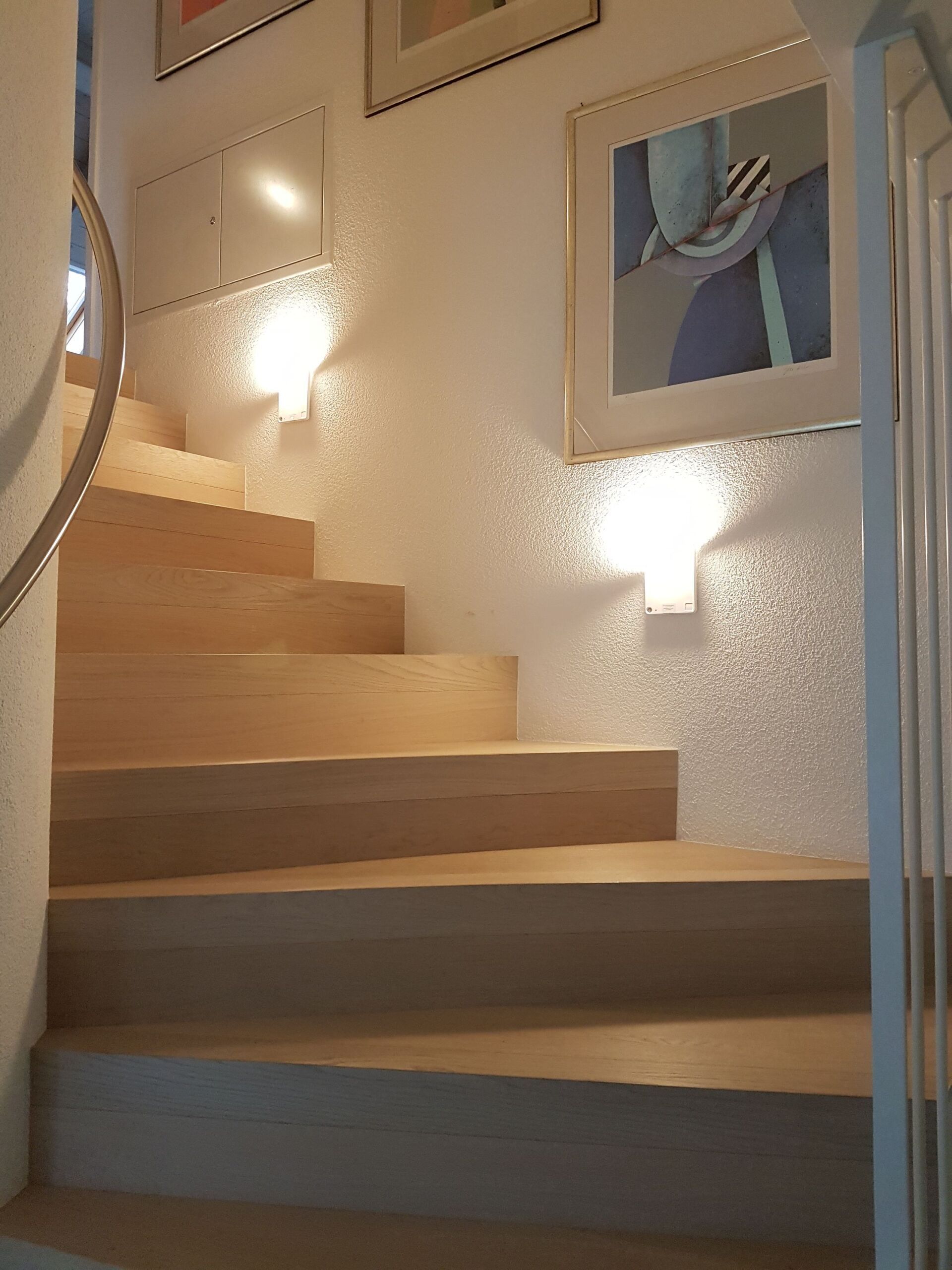 Eine Treppe mit Geländer und einem Bild an der Wand