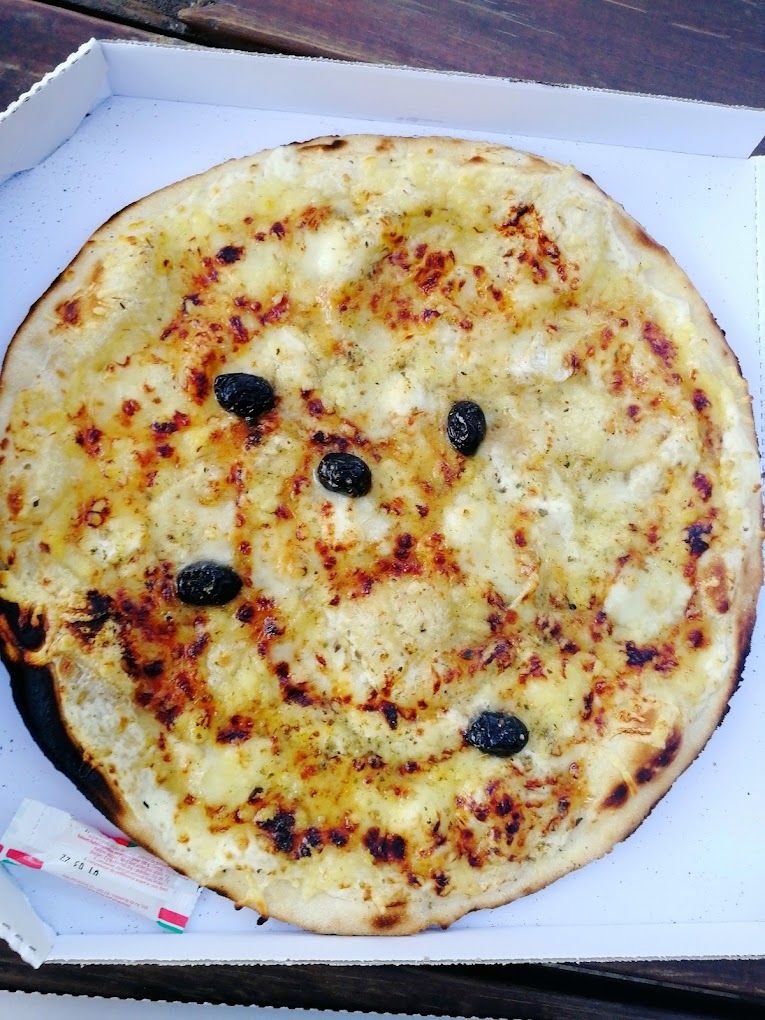 Une pizza base crème aux olives vue de haut
