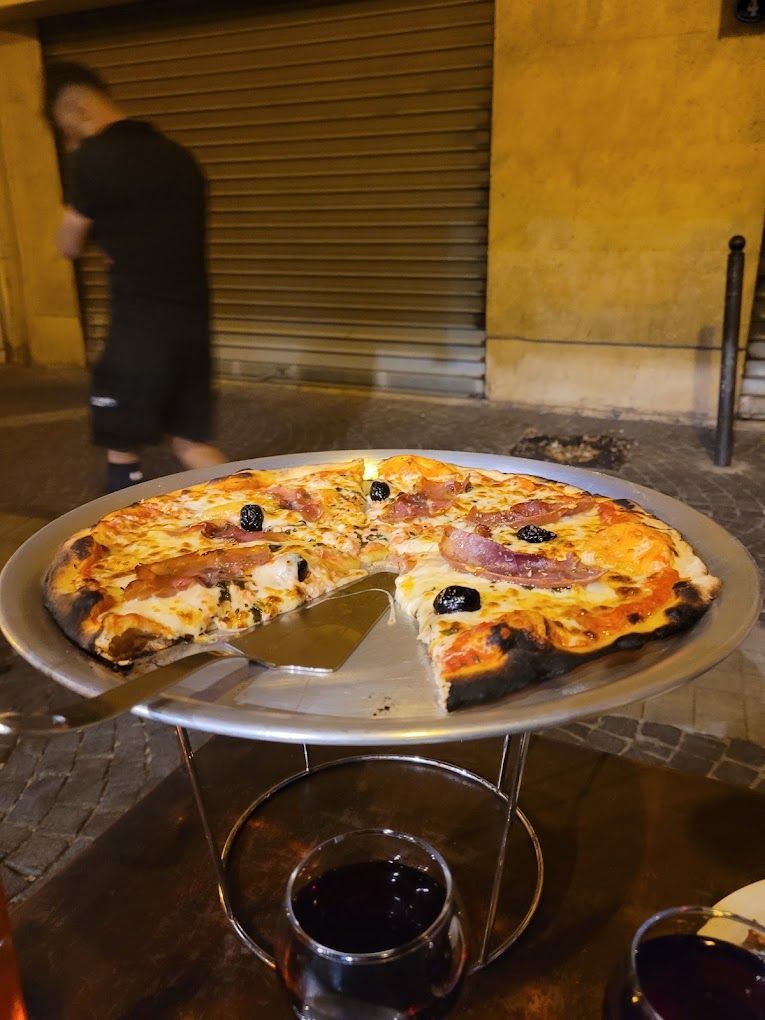 Une pizza avec une pelle à tarte en terrasse
