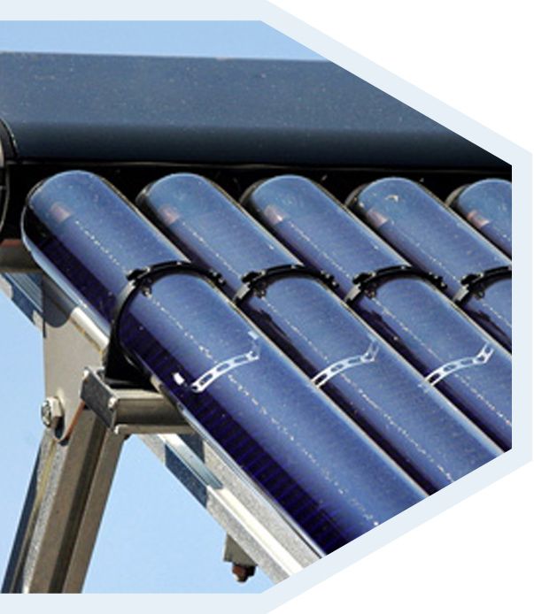 Gros plan sur un chauffe-eau solaire composé de tubes sous vide bleu foncé montés sur une structure métallique, sur fond de ciel bleu.