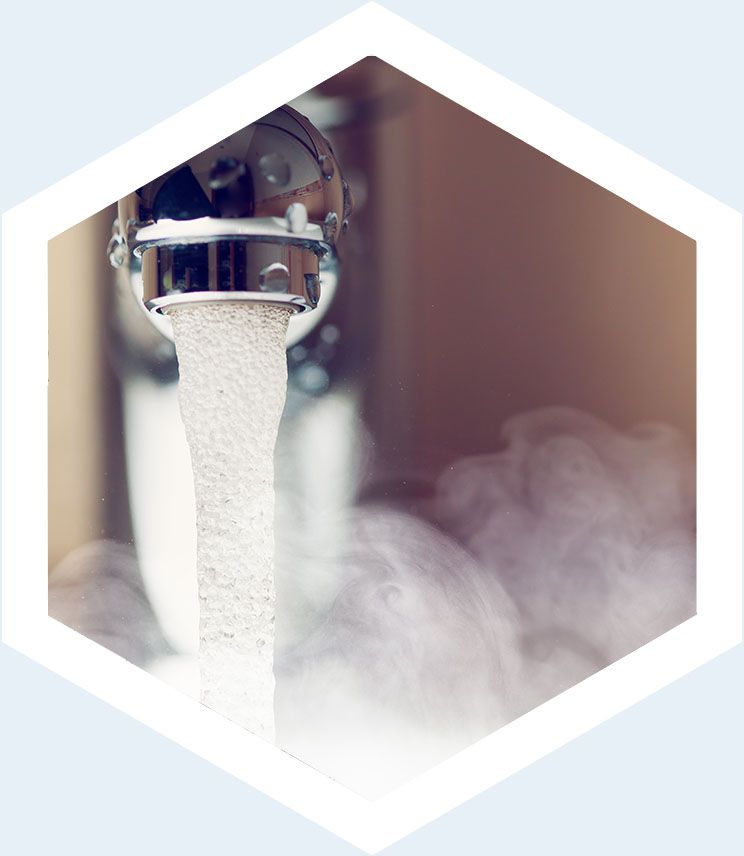Gros plan sur un robinet de cuisine déversant de l'eau bouillante dans un évier.