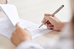 Une personne écrit au stylo.