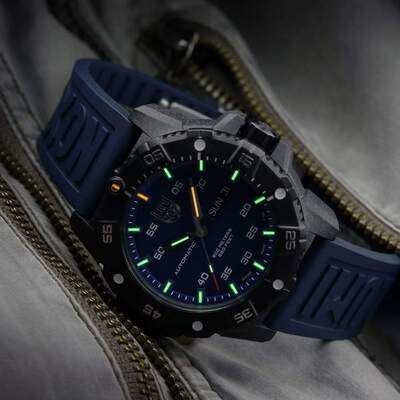 Schwarz-blaue Luminox-Uhr mit leuchtend grünen Zeigern und Ziffern auf einem blauen Kautschukarmband.