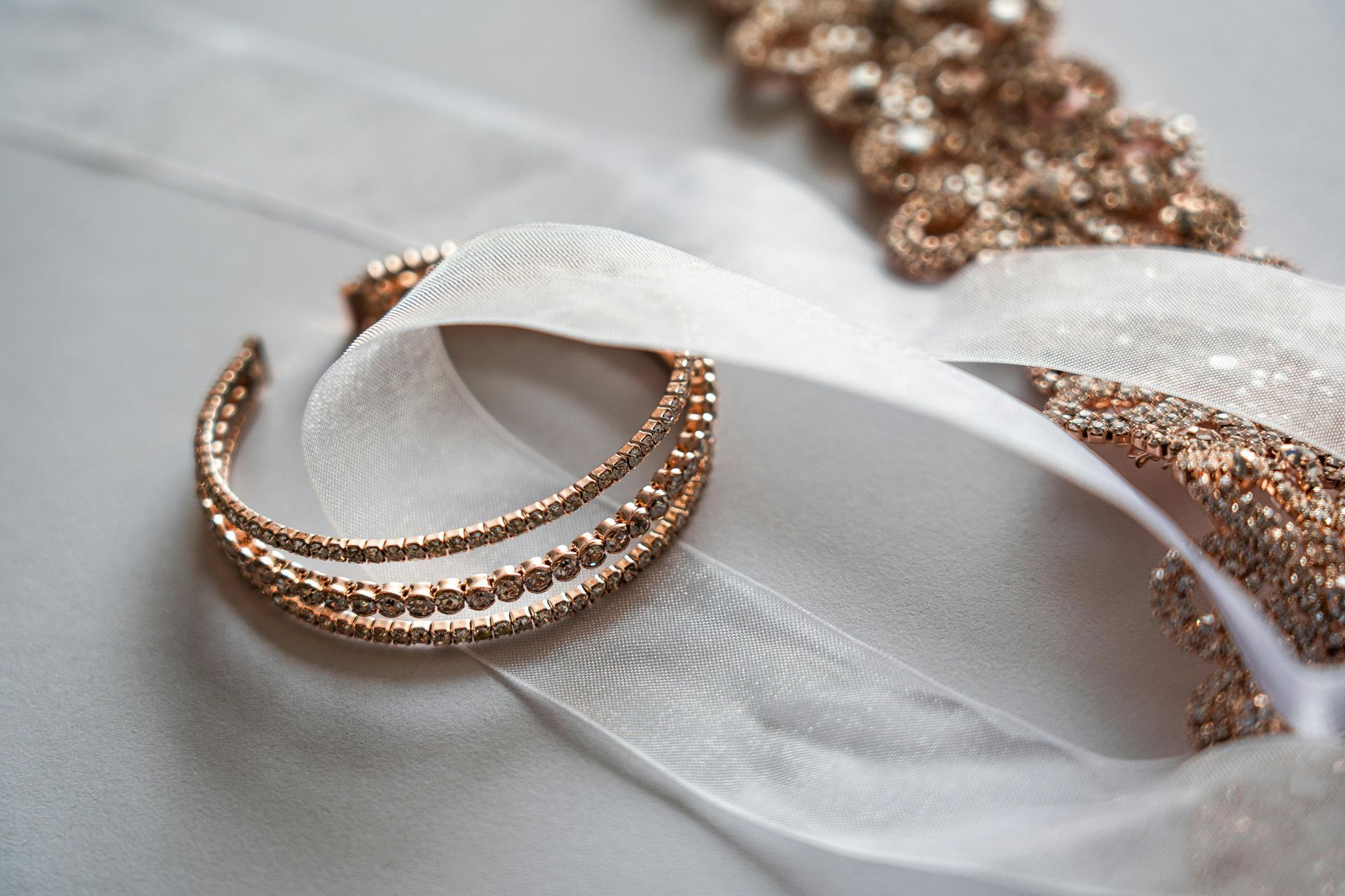 Goldene Armbänder und Perlenverzierungen auf weißem Band.