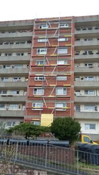 Ein hohes Gebäude mit einem Gerüst an der Seite.