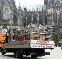 Vor einem großen Gebäude parkt ein LKW.