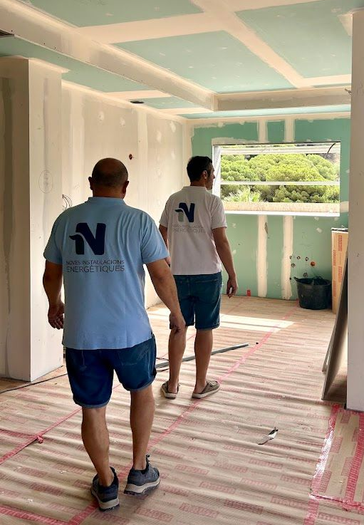 Peldaños de escalera de piedra gris contra paredes blancas; pasamanos negro visible.