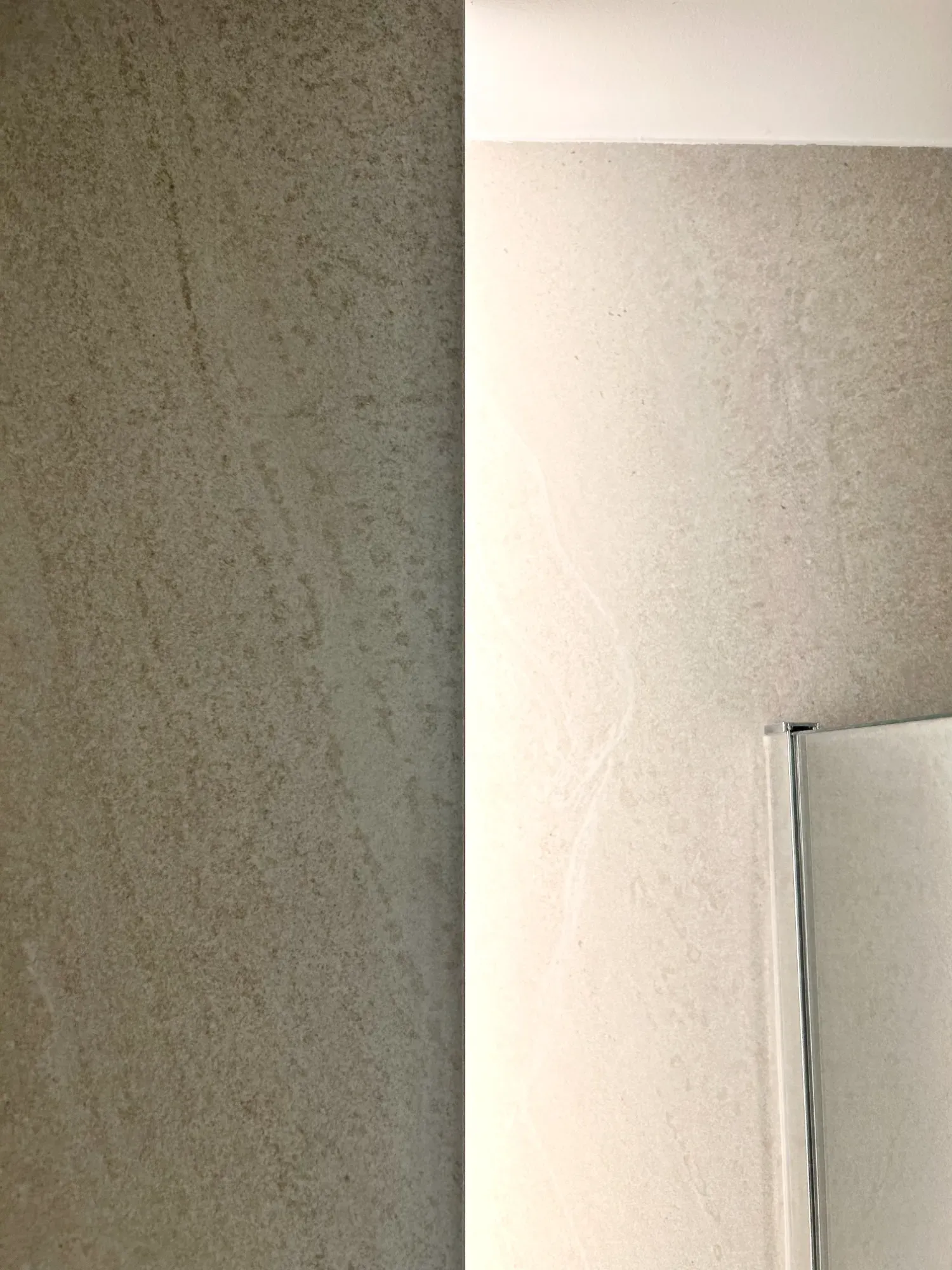 Dos paredes texturizadas, una beige claro y otra beige más oscuro, se encuentran en una esquina.