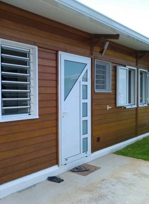 Maison en façade de bois avec une porte d'entrée blanche