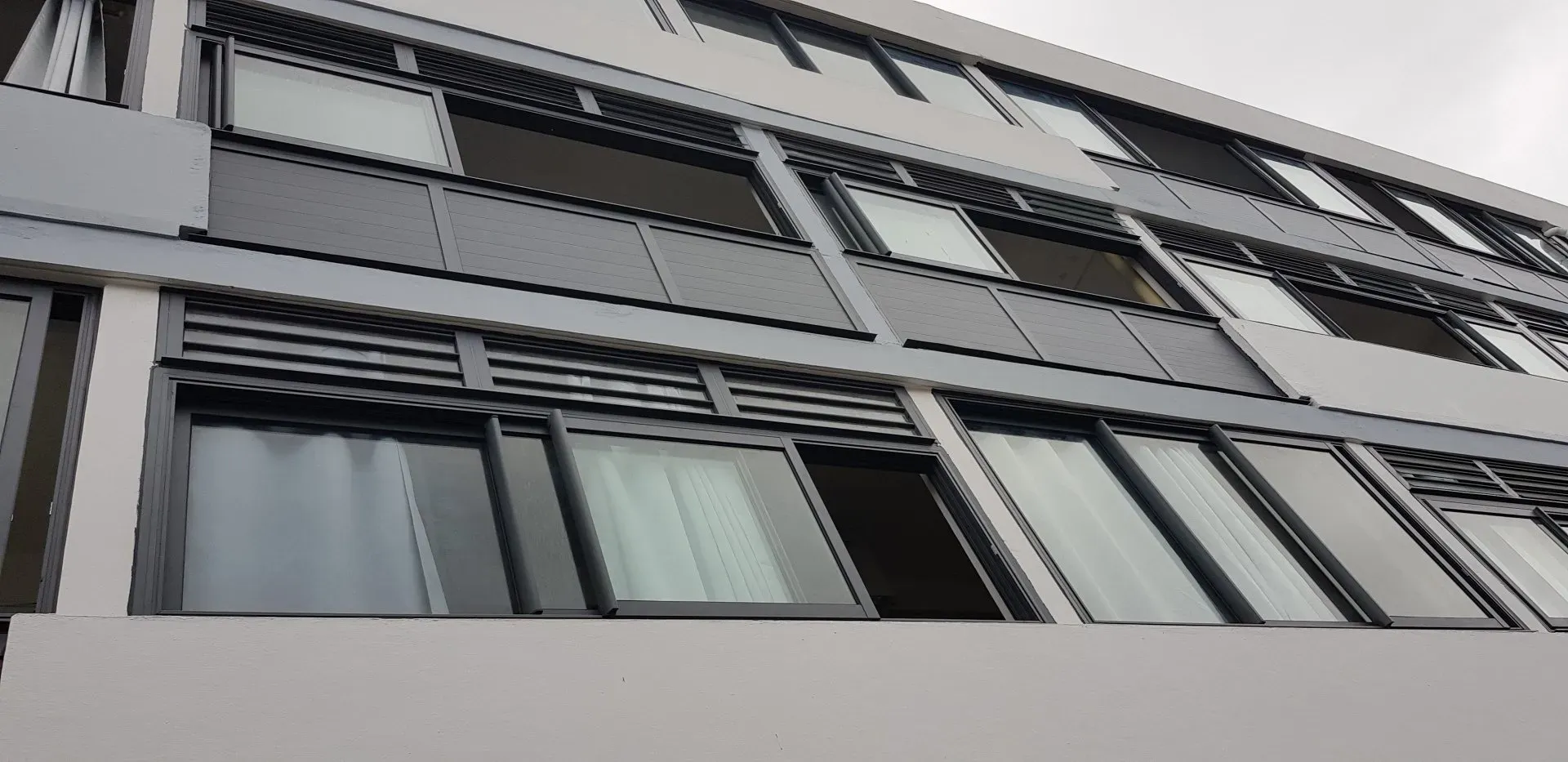 Vue d'un bâtiment avec des menuiseries foncées