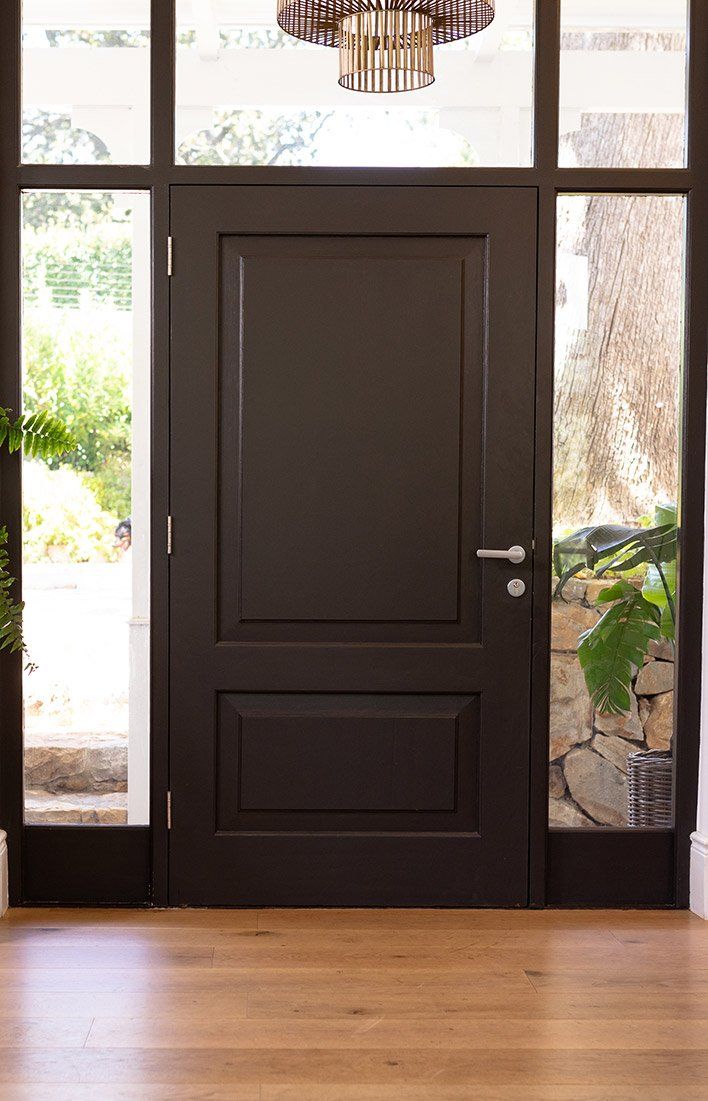 Porte d'entrée gris anthracite, entourée de vitres