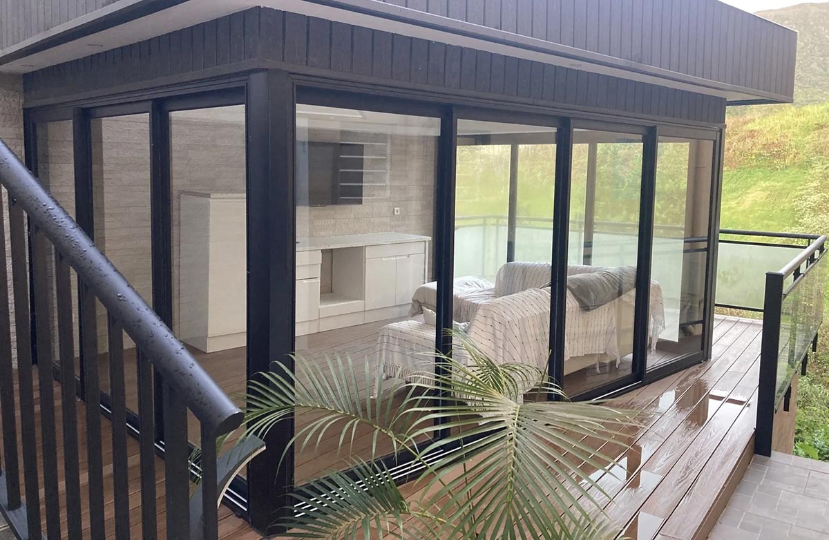 Véranda en armature sombre et son canapé blanc