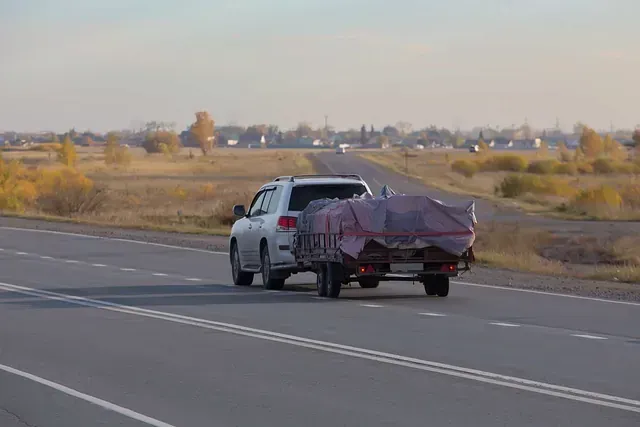 Un automóvil remolca un remolque en una carretera.