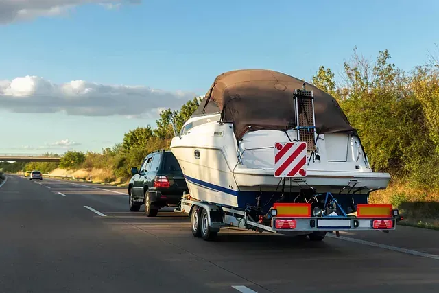 Un automóvil está remolcando un barco por una autopista.