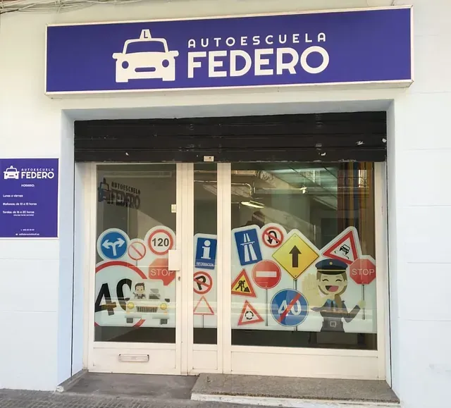 Un frente de tienda con un cartel morado que dice autoescuela federal