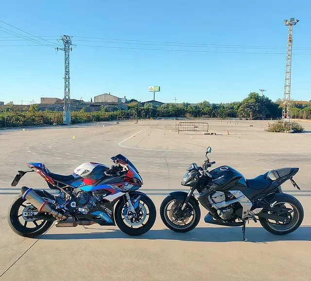 Dos motocicletas están estacionadas una al lado de la otra en un estacionamiento.