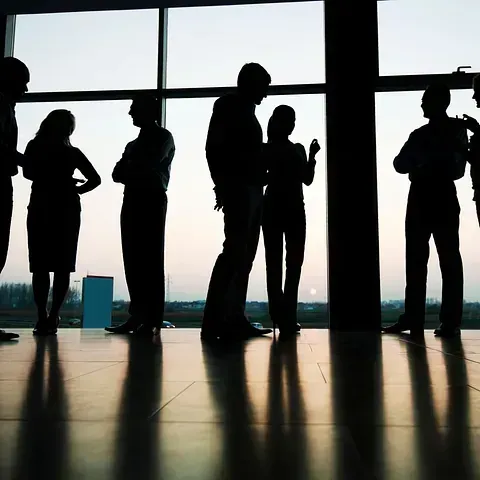 Un grupo de personas de pie frente a una gran ventana.