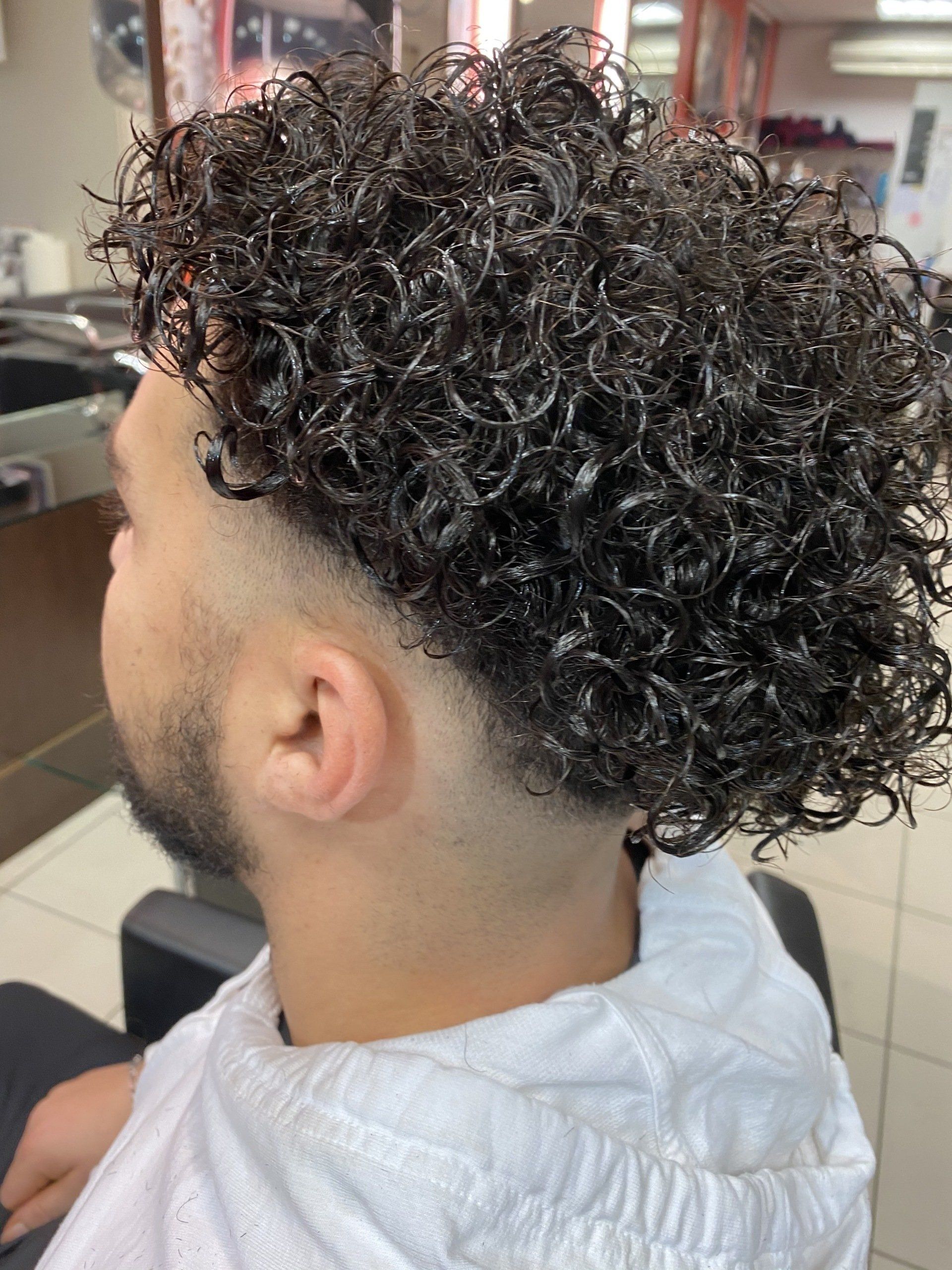 Des boucles réalisées sur les cheveux d'un homme