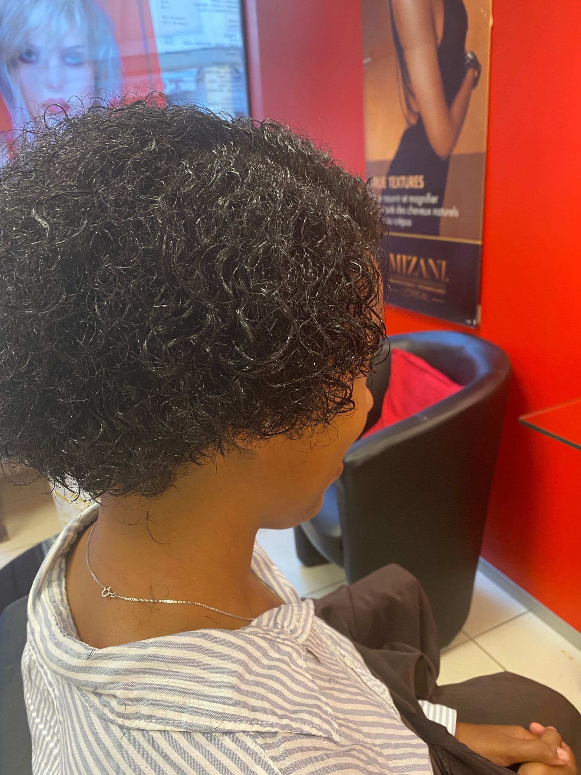 Des cheveux frisés avec la nuque dégagée