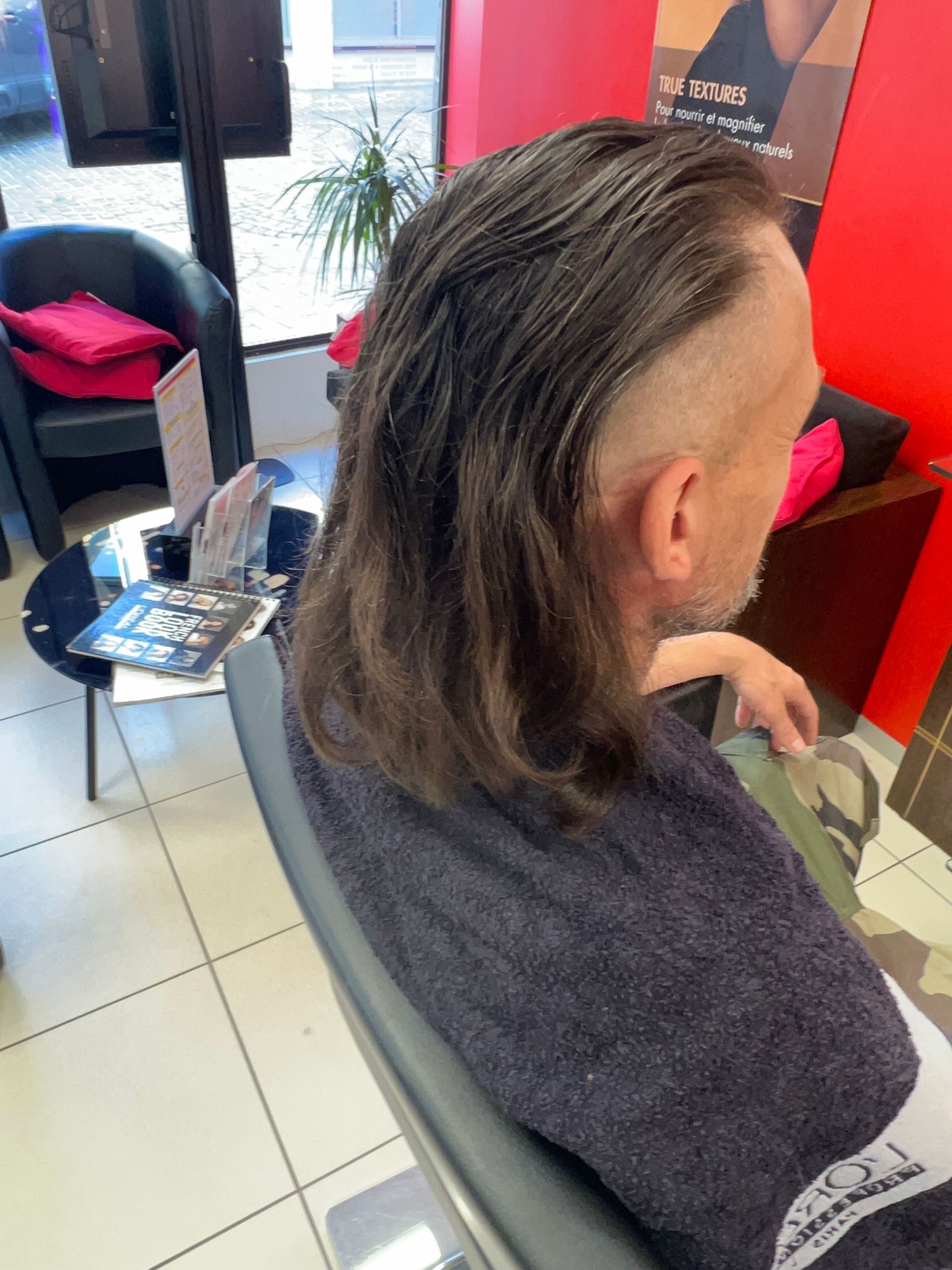 Un homme avec des cheveux mi-longs, rasés sur les côtés