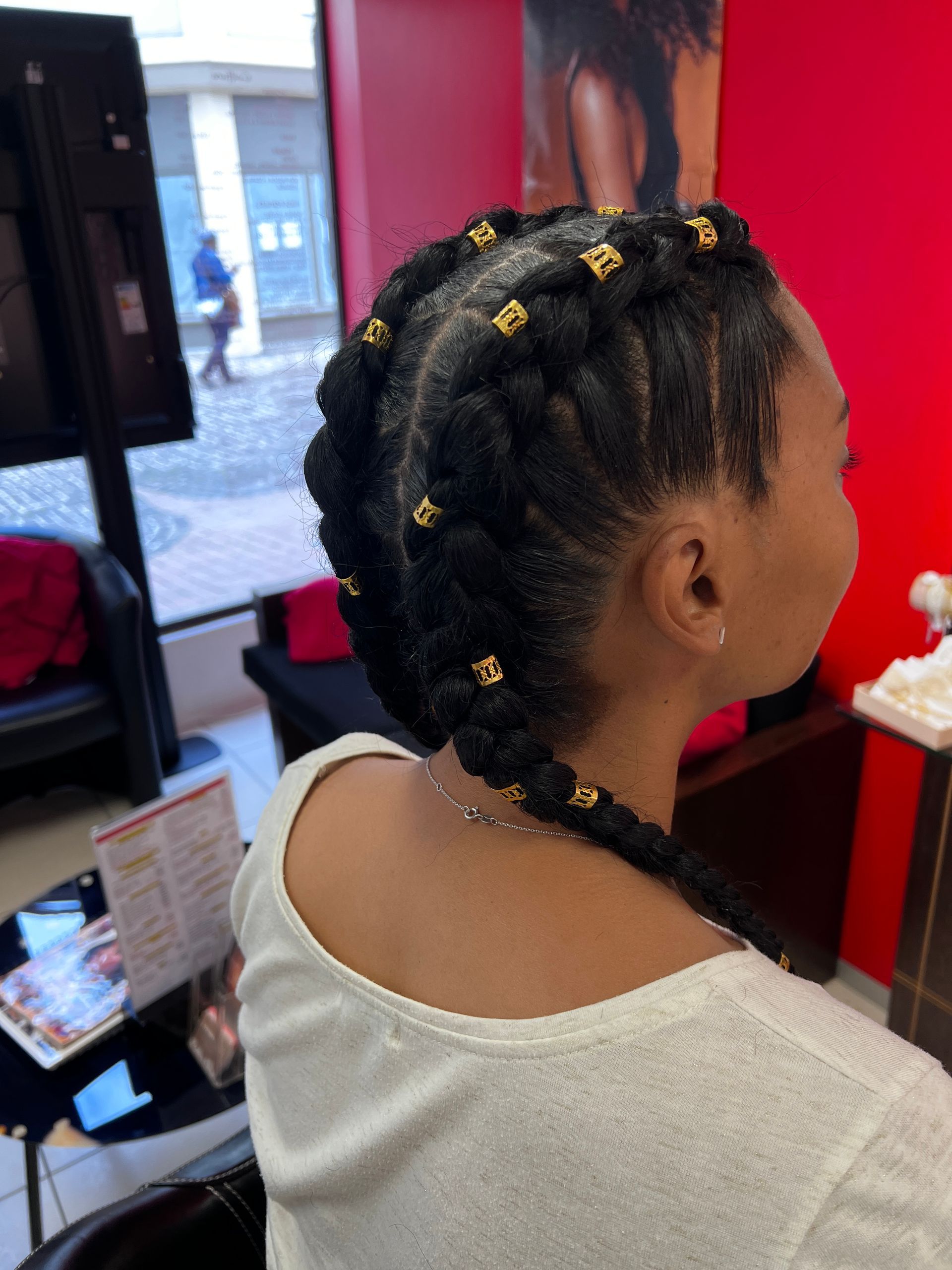 Des tresses collées avec des bijoux dans les cheveux