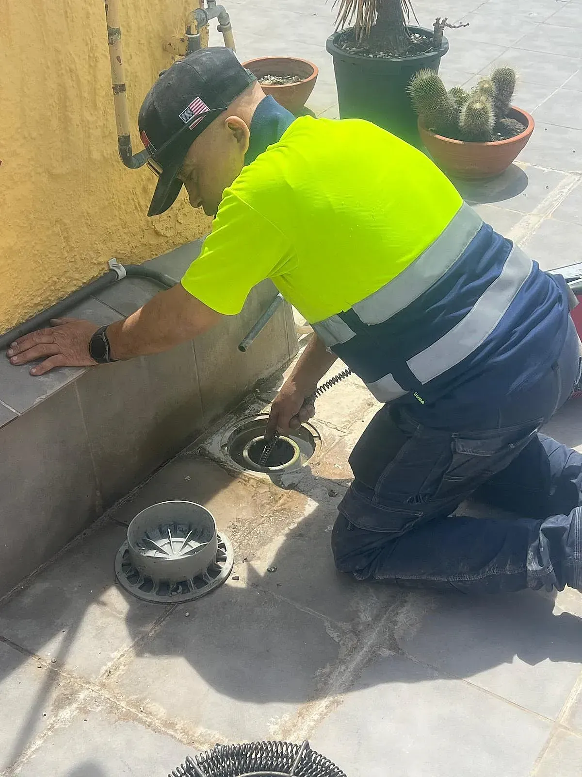Un hombre con una camisa de color amarillo neón está arrodillado en el suelo.