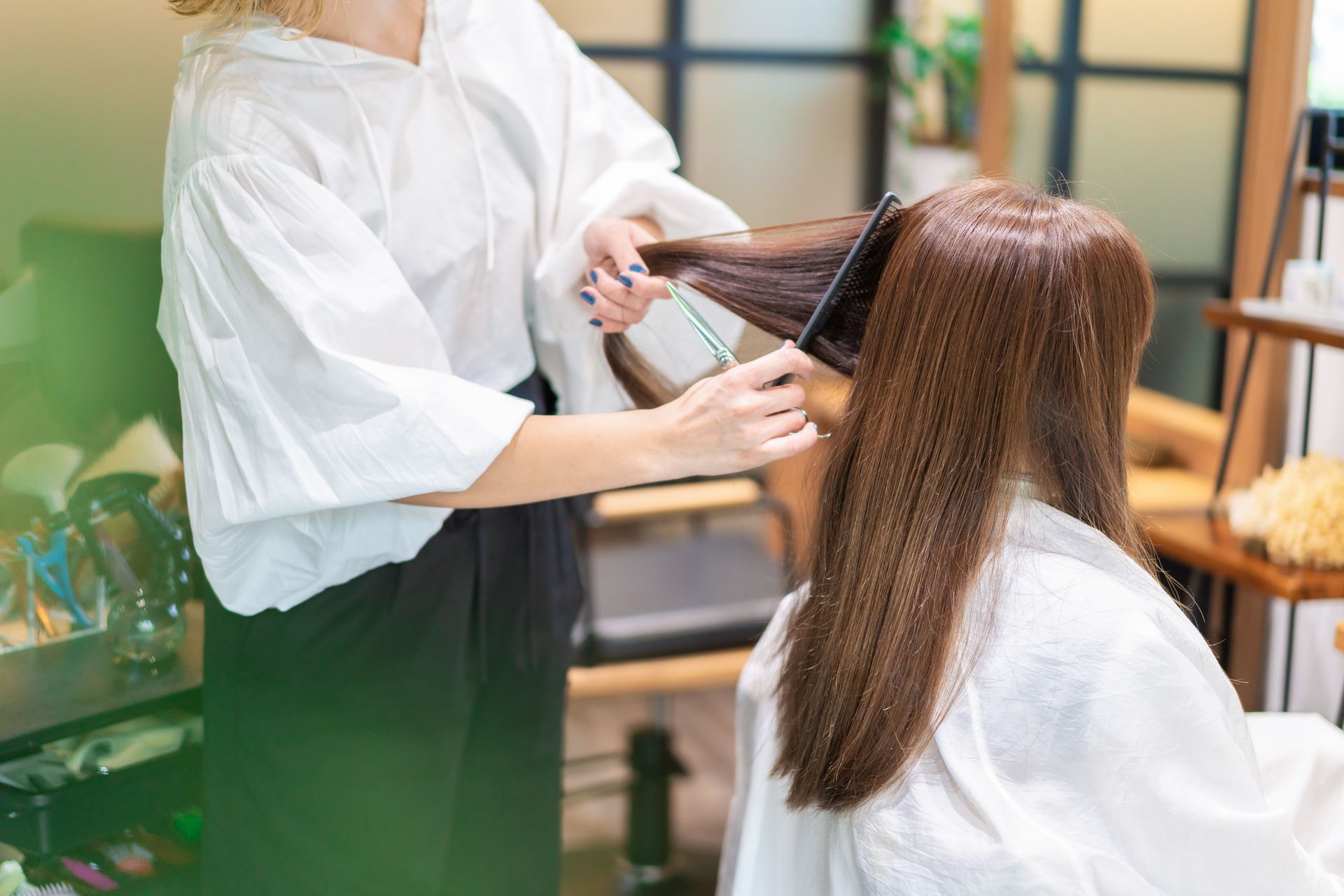 Coiffeuse qui coiffe une cliente