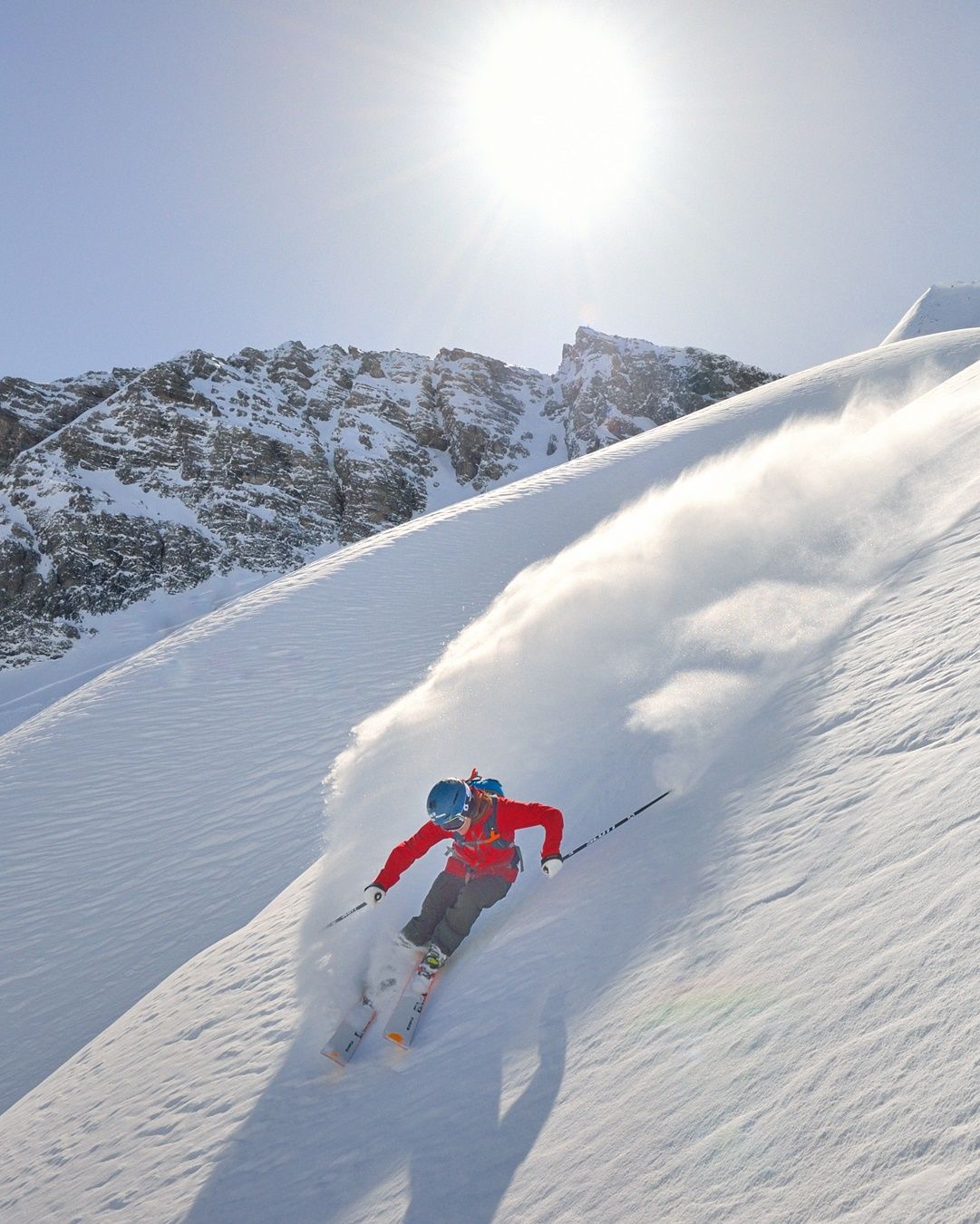 Ein Skifahrer fährt einen schneebedeckten Berg hinunter