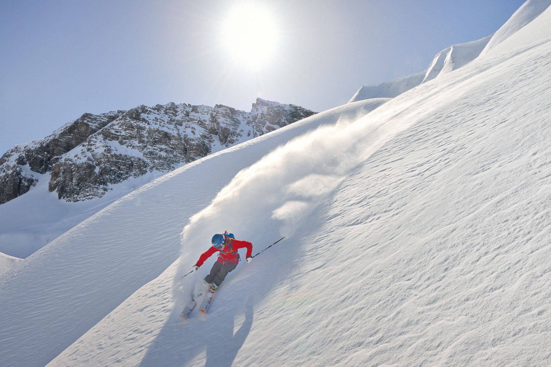 Ein Skifahrer fährt einen schneebedeckten Berg hinunter .