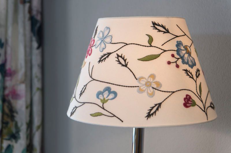 eine Lampe mit einem Blumenschirm darauf