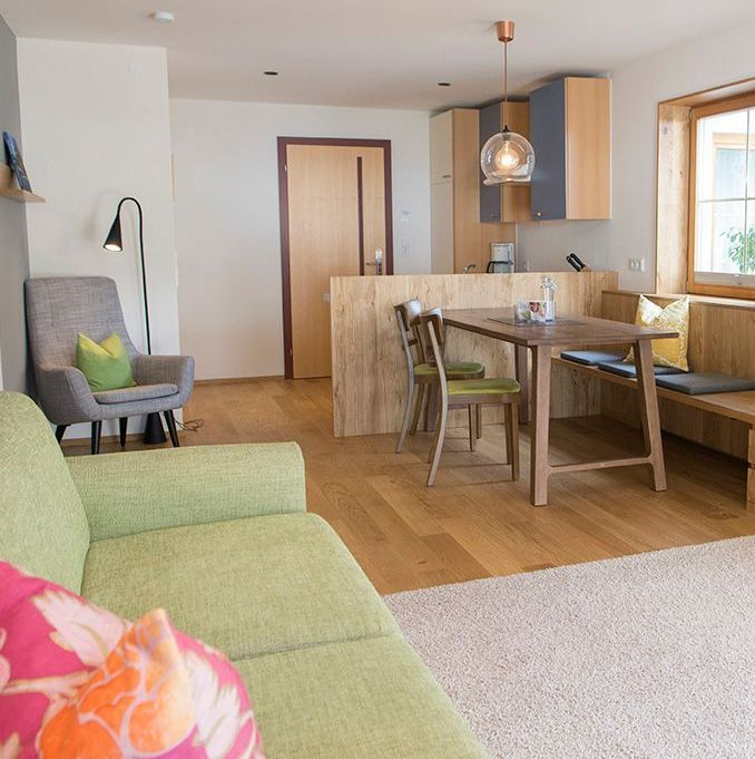 Wohnzimmer der Stäfeli Ferienwohnung mit einer grünen Couch , einem Stuhl und einem Tisch