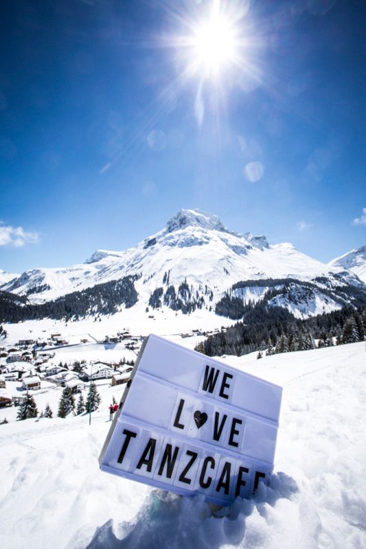 Auf einem schneebedeckten Berg steht ein Schild , das sagt , wir lieben Tanzcafe .