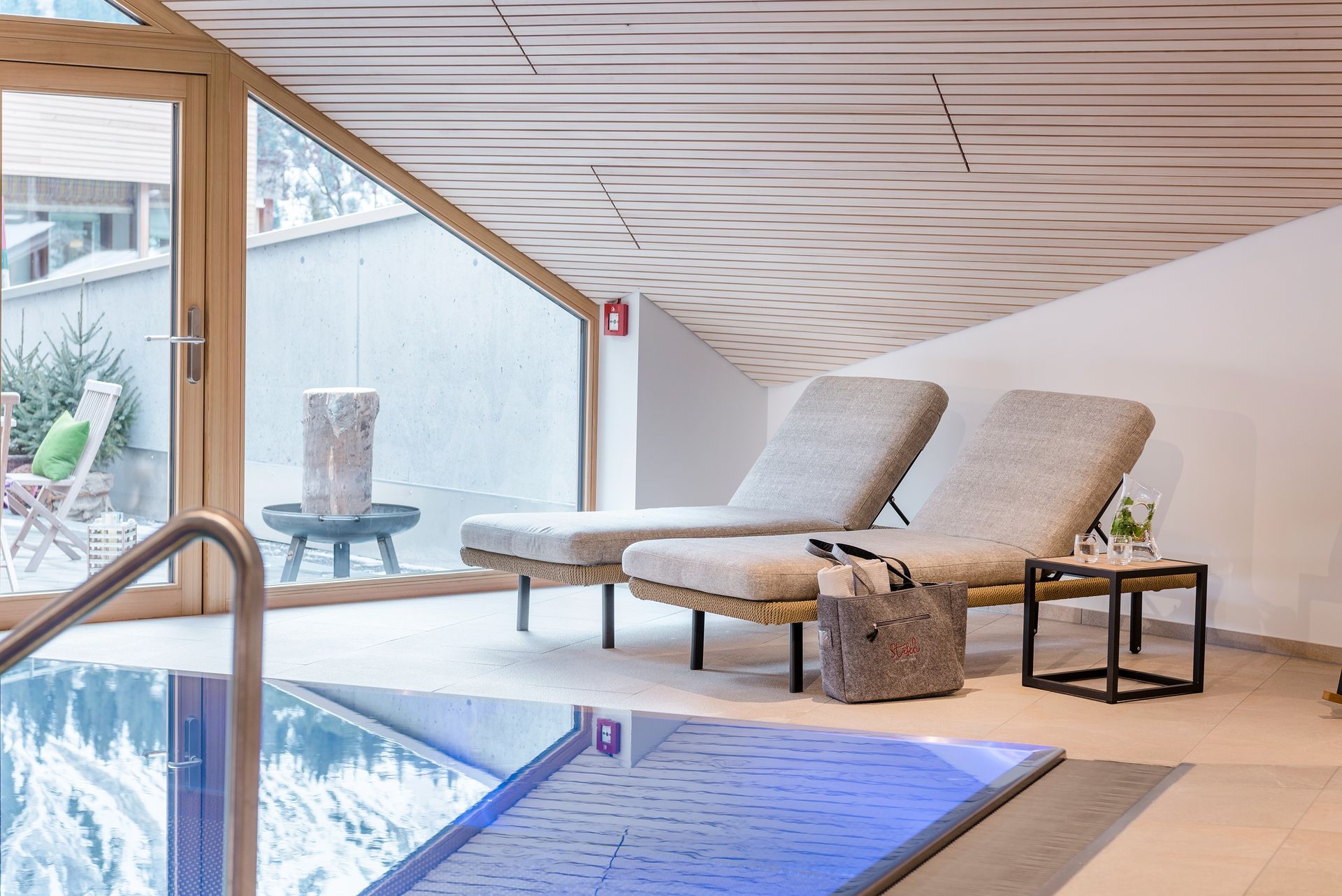 ein Swimmingpool mit Liegestühlen und einem Tisch davor .
